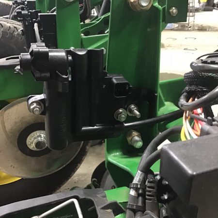 A close look at a vApply HD module installed on the "goal-post" of the row unit. On this planter and this row the module will control the 2x2 metering/clutch.